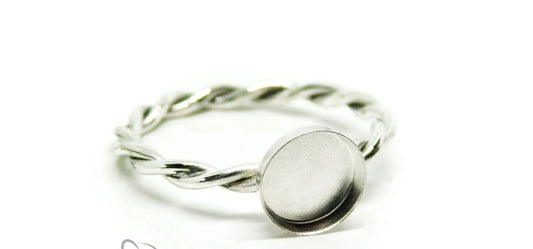 Silver ring with a round, flat surface on a white background